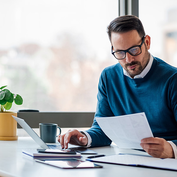 Young professional man using a laptop to search for an accountant near her